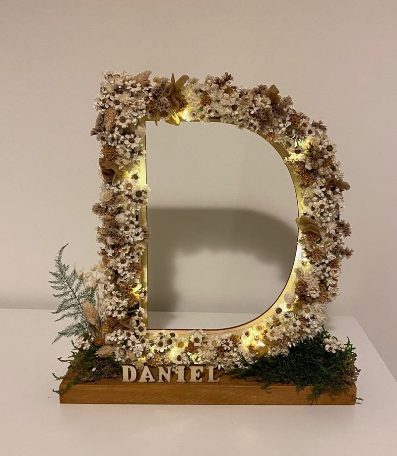 Letra D floral iluminada con flor preservada